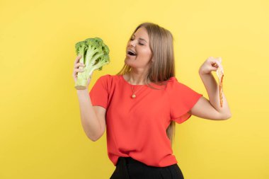 Brokoli ve lezzetli pizza tutan güzel bir kadın modeli resmi. Yüksek kalite fotoğraf