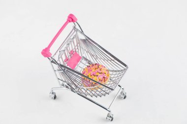 Beyaz arka planda metalik küçük el arabasıyla renklendirilmiş taze bir kurabiye. Yüksek kalite fotoğraf