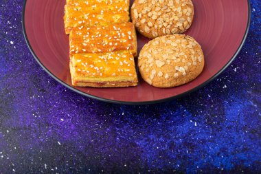 Galaksi masasına yerleştirilmiş tatlı krakerli yulaflı kurabiye tabağı. Yüksek kalite fotoğraf
