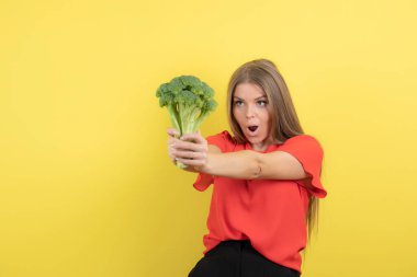 Büyük yeşil brokoli tutan güzel bir kadın modeli resmi. Yüksek kalite fotoğraf