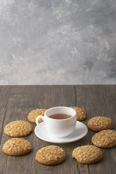 Biscoitos Aveia Com Sementes Perto Uma Xícara Branca Chá Preto — Fotografia de Stock