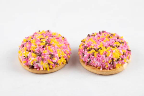 Two Tasty Cookies Decorated Sprinkles Placed White Background High Quality — Stock Photo, Image