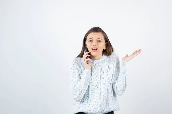 Niña Usando Suéter Posando Con Teléfono Inteligente Sobre Fondo Blanco — Foto de Stock