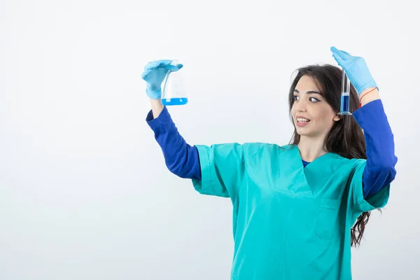 Kvinnlig Laboratoriearbetare Som Experimenterar Med Kemisk Kolv Över Vit Vägg — Stockfoto
