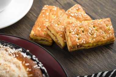 Tahta zemin üzerinde hindistan cevizi parçacıkları ve bisküviler olan bir tabak tatlı turta. Yüksek kalite fotoğraf