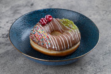 Bir çikolatalı donut ve bir tabağa serpiştirilmiş. Yüksek kalite fotoğraf
