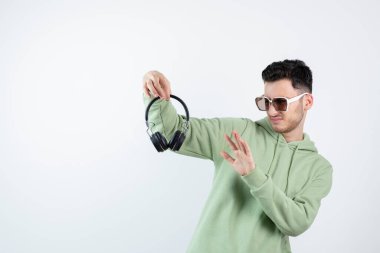 Gözlüklü yakışıklı bir adam kulaklığa bakıyor. Yüksek kalite fotoğraf