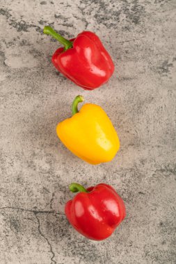 Taş yüzeyine yerleştirilmiş üç tane olgun dolma biber. Yüksek kalite fotoğraf