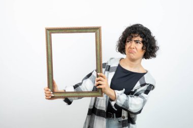 Esmer, güzel bir kadın, elinde eski, ahşap bir çerçeve tutuyor. Yüksek kalite fotoğraf