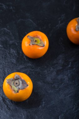 Siyah yüzeye yerleştirilmiş lezzetli olgun hurma meyveleri. Yüksek kalite fotoğraf