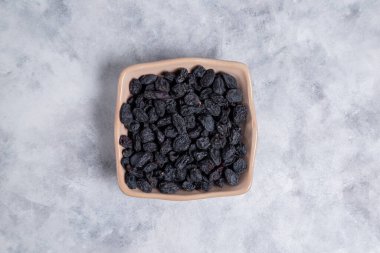 Kurumuş kuru üzümler mermer arka planda kaselerde. 
