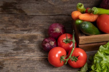 Tahta bir masanın üzerine taze olgun sebzelerle dolu ahşap bir kutu. Yüksek kalite fotoğraf