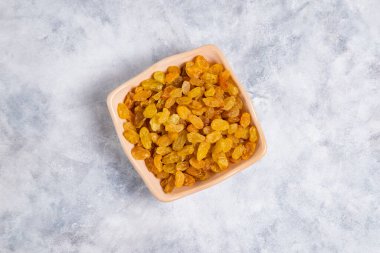 Kurumuş kuru üzümler mermer arka planda kaselerde. 