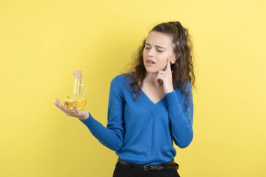 Elinde cam bir yağ şişesi tutan genç ve güzel bir kızın fotoğrafı. Yüksek kalite fotoğraf