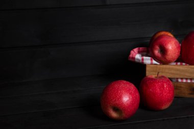 Bütün ve dilimlenmiş kırmızı elmalar koyu ahşap bir masanın üzerine yerleştirildi. Yüksek kalite fotoğraf