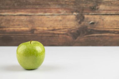 Ahşap bir arka planda tamamen yeşil bir elma. Yüksek kalite fotoğraf