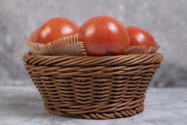 Sulu kırmızı domatesler sepetin içinde mermer bir arka planda. Yüksek kalite fotoğraf