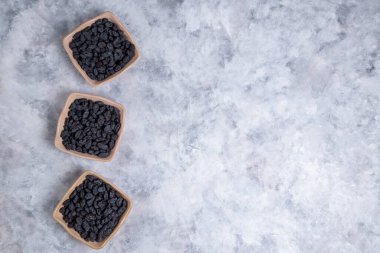 Kurumuş kuru üzümler mermer arka planda kaselerde. 