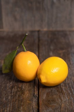 Tahta bir masanın üzerine yapraklı taze limon meyveleri. Yüksek kalite fotoğraf