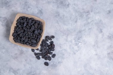 Kurumuş kuru üzümler mermer arka planda kaselerde. 