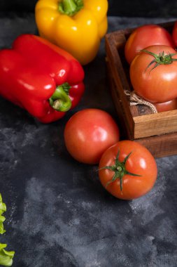 Tahta bir kutuda sulu domatesli sarı ve kırmızı dolma biber. Yüksek kalite fotoğraf