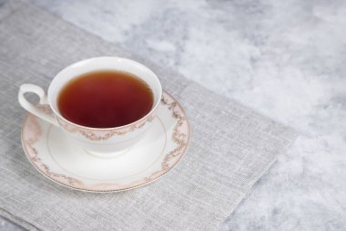 Bir fincan çay ve tahta arka planda beyaz bir kupa.