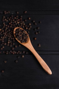 Koyu ahşap bir masaya konmuş, biber dolu bir tahta kaşık. Yüksek kalite fotoğraf