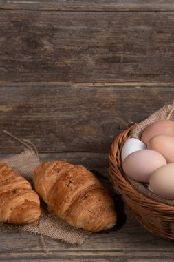 Tahta yüzeyde taze kruvasan ve çiğ yumurta. Yüksek kalite fotoğraf
