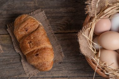Tahta yüzeyde taze kruvasan ve çiğ yumurta. Yüksek kalite fotoğraf