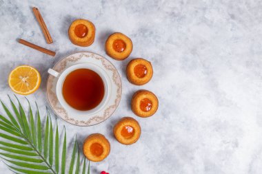 Beyaz arka planda limonlu çay fincanı ve tarçın çubukları. en üstteki görünüm.