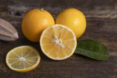 Yapraklı taze limon meyveleri ve ahşap bir masaya yerleştirilmiş ahşap bir kağıt. Yüksek kalite fotoğraf