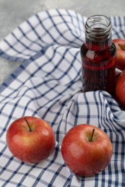 Lezzetli kırmızı elmalar ve çizgili masa örtüsünün üzerinde bir bardak kırmızı meyve suyu. Yüksek kalite fotoğraf