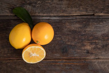 Tahta bir masanın üzerine yapraklı taze limon meyveleri. Yüksek kalite fotoğraf