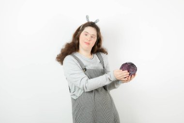 Mor lahana tutan Down sendromlu sevimli bir kızın fotoğrafı. Yüksek kalite fotoğraf