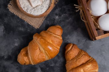 Tavuk yumurtalı taze kruvasan ve ahşap un kasesi. Yüksek kalite fotoğraf