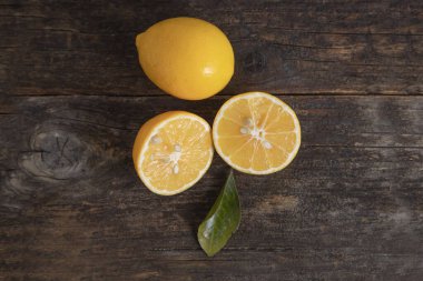 Tahta bir masanın üzerine yapraklı taze limon meyveleri. Yüksek kalite fotoğraf