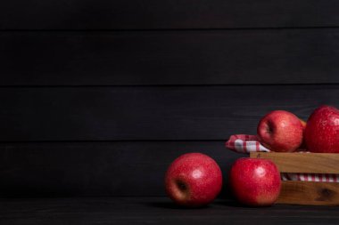 Koyu arkaplana yerleştirilmiş ahşap kutu kırmızı elma. Yüksek kalite fotoğraf