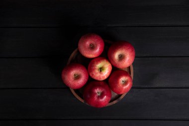Tahta kasedeki kırmızı elmalar, siyah bir tahta masaya konur. Yüksek kalite fotoğraf