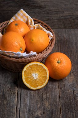 Hasır sepete yerleştirilmiş lezzetli taze portakallar. Yüksek kalite fotoğraf