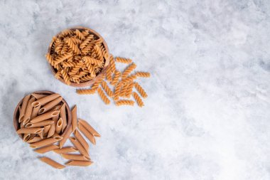 Tahta kaseler, taş masaya konmuş pişmemiş İtalyan makarnası. Yüksek kalite fotoğraf