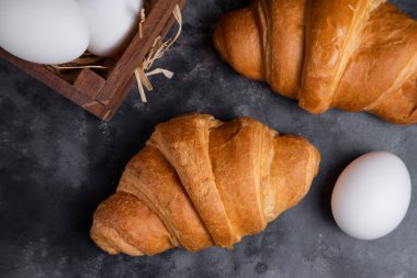 Tavuk yumurtalı taze kruvasan ve ahşap un kasesi. Yüksek kalite fotoğraf