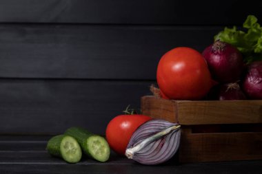 Koyu ahşap bir masanın üzerine taze olgun sebzelerle dolu ahşap bir kutu. Yüksek kalite fotoğraf