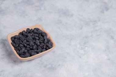 Kurumuş kuru üzümler mermer arka planda kaselerde. 