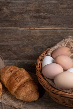 Tahta yüzeyde taze kruvasan ve çiğ yumurta. Yüksek kalite fotoğraf