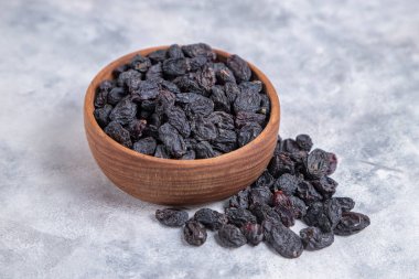 Kurumuş kuru üzümler mermer arka planda kaselerde. 