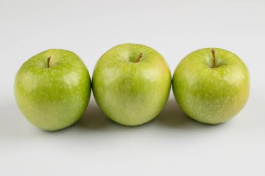Three fresh green apples placed on white background. High quality photo