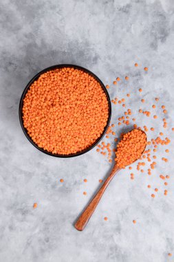 Tahta kaşıkla çiğ kırmızı mercimek çekirdeği dolu bir kase. Yüksek kalite fotoğraf