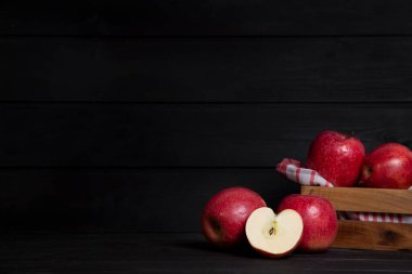 Bütün ve dilimlenmiş kırmızı elmalar koyu ahşap bir masanın üzerine yerleştirildi. Yüksek kalite fotoğraf