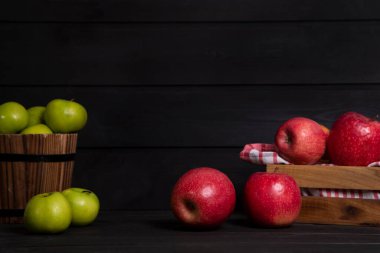 Ahşap kutu kırmızı elma ve koyu arkaplanda yeşil elma. Yüksek kalite fotoğraf