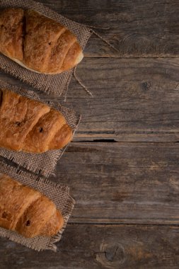 Ahşap yüzeye yerleştirilmiş lezzetli taze kruvasanlar. Yüksek kalite fotoğraf